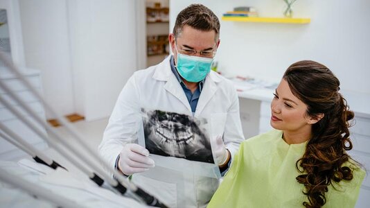 dentist-talking-with-patient-at-exam.jpg