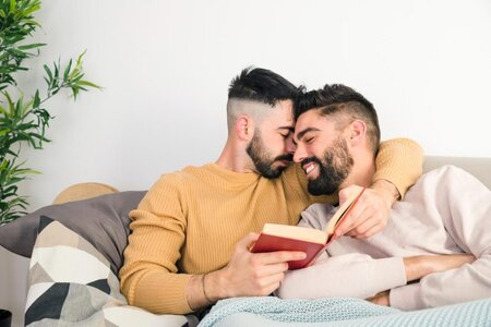 romantic-gay-couple-lying-sofa-against-white-wall-1024x683.jpg