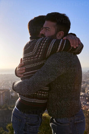 loving-gay-men-embracing-while-standing-against-clear-sky-during-sunrise-bunkers-del-carmel-ba...jpg