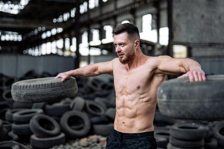 man-lifts-two-tires-shirtless.jpg