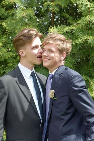 Gay couple in suits and ties being mischievous at a wedding_.jpeg