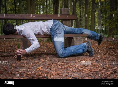 depressed-drunk-man-asleep-outdoor-on-a-park-bench-with-beer-bottles-2E43XA8.jpg