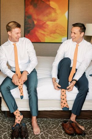 Couple Getting Ready with Matching Orange Ties and Patterned Socks.jpeg