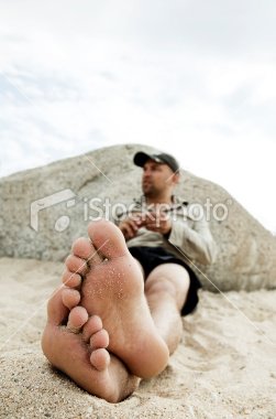 stock-photo-10694730-male-feet-on-sand.jpg
