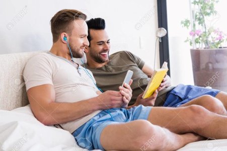 52102858-happy-gay-couple-reading-book-on-bed.jpg